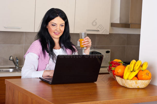 微笑女子在厨房起诉笔记本电脑