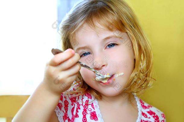 饥肠辘辘的金发小女孩<strong>用勺子</strong>吃冰淇淋