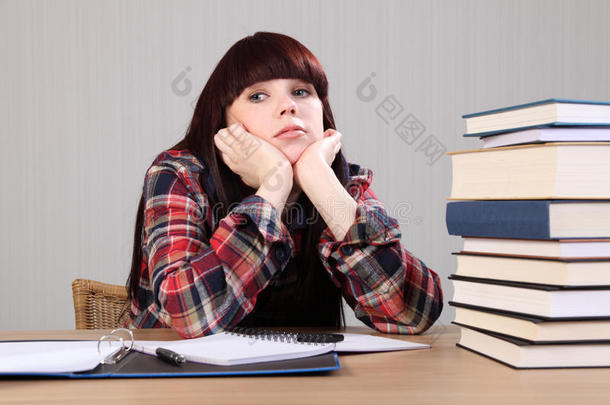 年轻的学生女孩累了，做作业休息