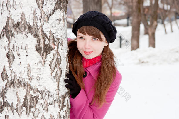 在白桦附近的冬季公园里的女人