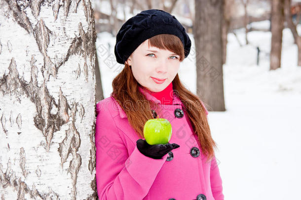 手拿青苹果的桦树旁的女人