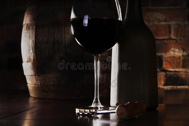 玻璃杯、酒桶和一瓶红酒