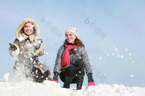 两个年轻女子蹲着下雪