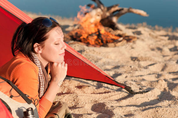 野营快乐的女人在营火旁的帐篷里放松