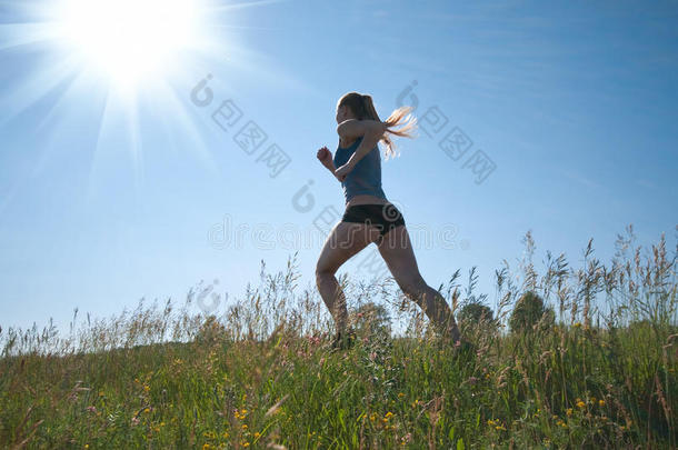 女运动员在青草和天空上奔跑