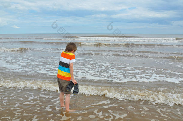 可爱的小男孩在沙滩上乘凉