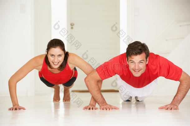 夫妻俩在家庭健身房做俯卧撑