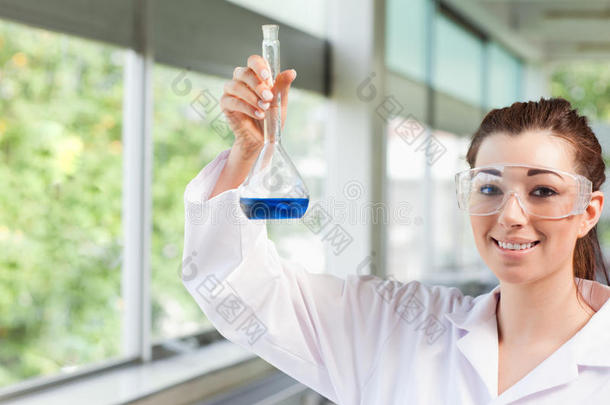 女理科学生拿着蓝色的液体