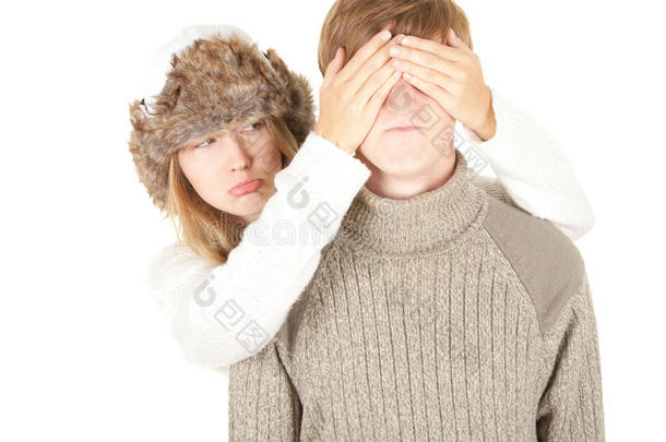 戴着冬帽的伤心女孩遮住了男朋友的眼睛