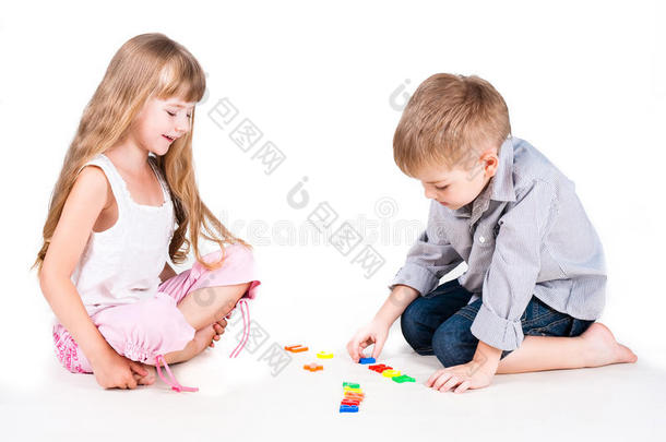 两个玩字母表被隔离在白色上的孩子