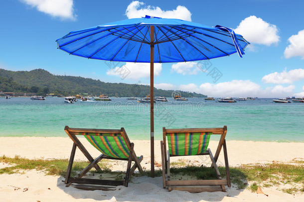 蓝色沙滩伞和条纹躺椅