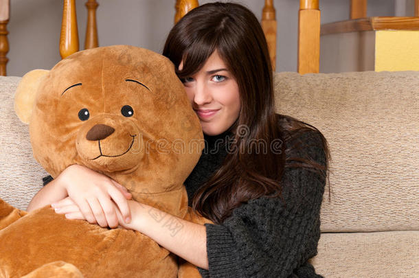 <strong>坐在沙发上</strong>抱着泰迪熊的年轻<strong>女子</strong>
