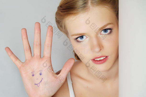 漂亮的积极女孩用绘画展示了一只手掌