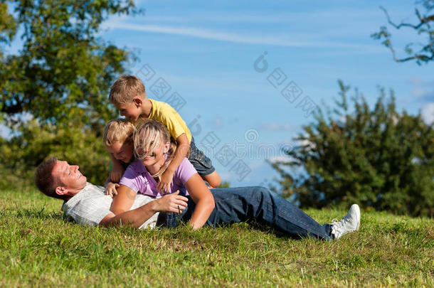 有孩子在草地上玩耍的家庭