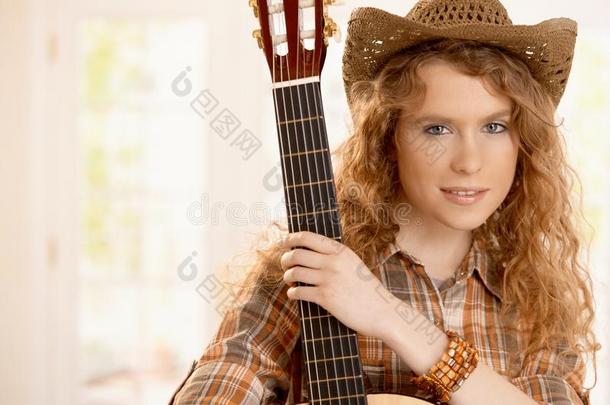 漂亮的吉他手女孩抱着吉他