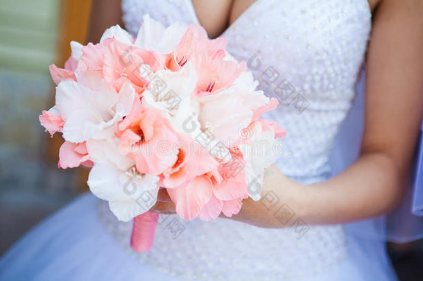 新娘拿着<strong>淡淡的</strong>粉红色花束
