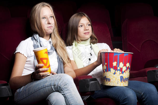 两个漂亮的女孩在电影院看电影