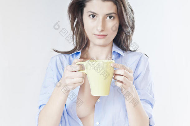 睡意朦胧的女人，衬衫里放着一杯咖啡