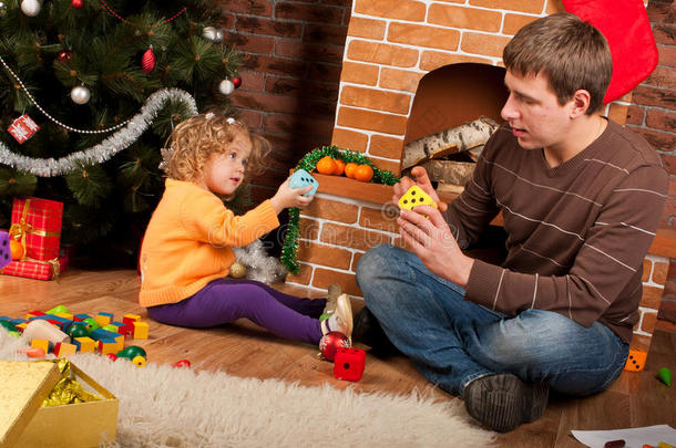 小女孩和爸爸在圣诞树附近玩耍