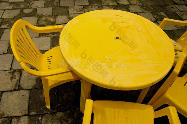 黄色塑料桌椅，用于户外休闲。