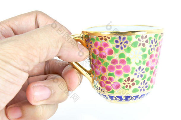 手拿金泰国茶杯