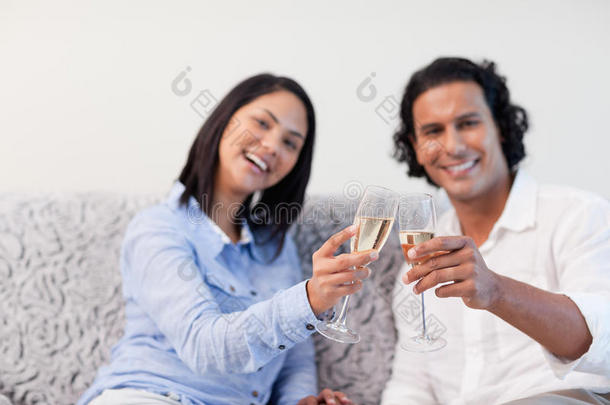 夫妻俩在沙发上用起泡酒庆祝