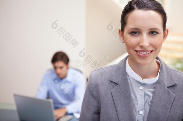 带着微笑的女商人和同事在他的笔记本电脑上工作