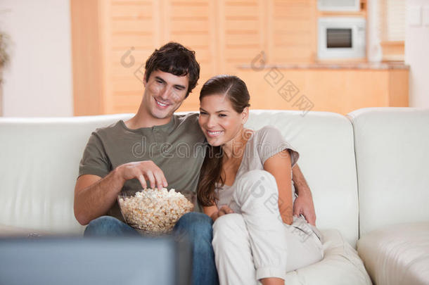 夫妻俩在沙发上吃爆米花看电影