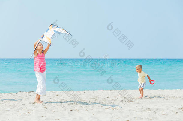 和哥哥在海滩上玩风筝的女孩