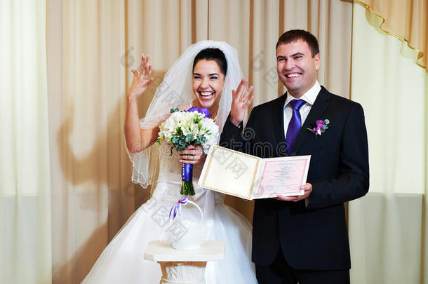 新娘和新郎展示戒指和证书