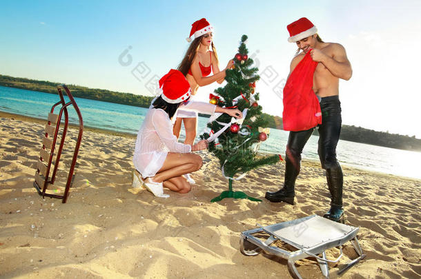 圣诞老人的助手和热带海滩上的圣诞老人