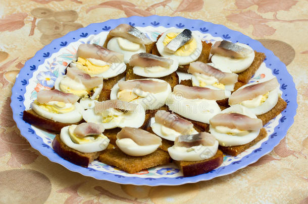 盘子里有鸡蛋和鱼的三明治