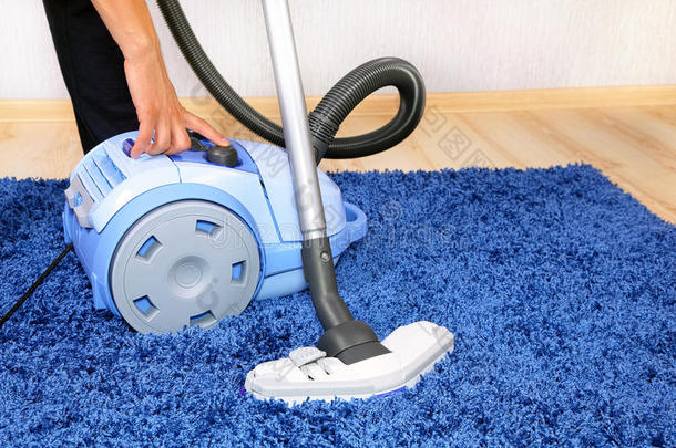 吸尘器在行动男人清洁地毯。