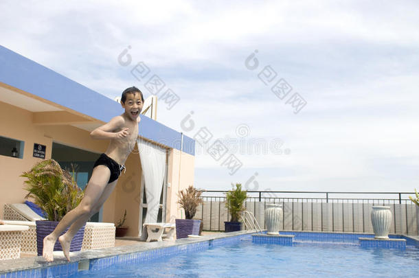 亚洲男孩跳入游泳池
