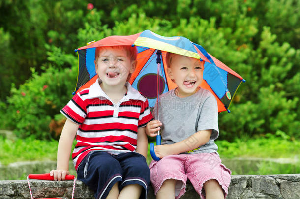 两个有趣的孩子和雨伞。夏雨