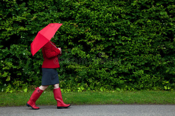 红衣女子撑伞散步
