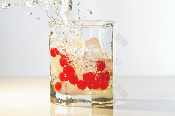 一杯杜松子酒，冰和红蔓越莓，溅起水花