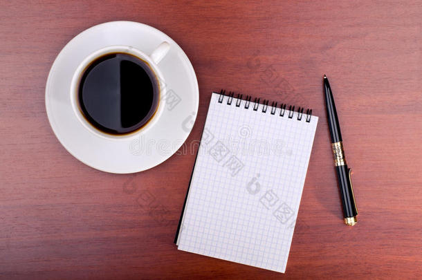 一杯咖啡，一本笔记本和一支笔