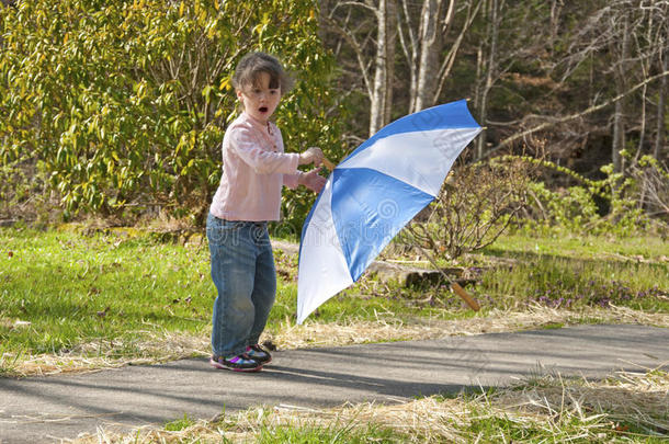 在<strong>刮风</strong>天玩伞的小女孩。