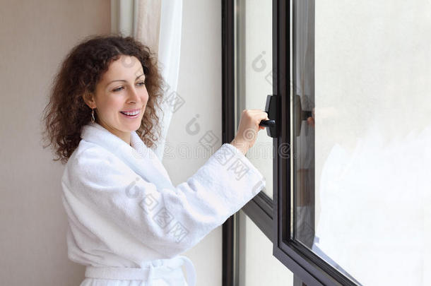 穿白色浴袍的女人打开窗户