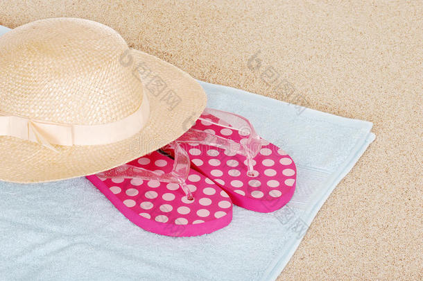 沙滩毛巾上的凉鞋帽