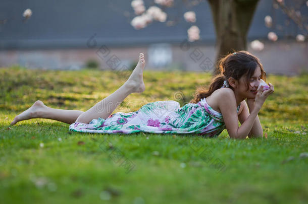 可爱的女孩<strong>梦幻</strong>般地躺在草地上