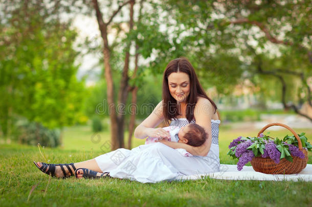 快乐的妈妈和宝宝在夏日公园休息