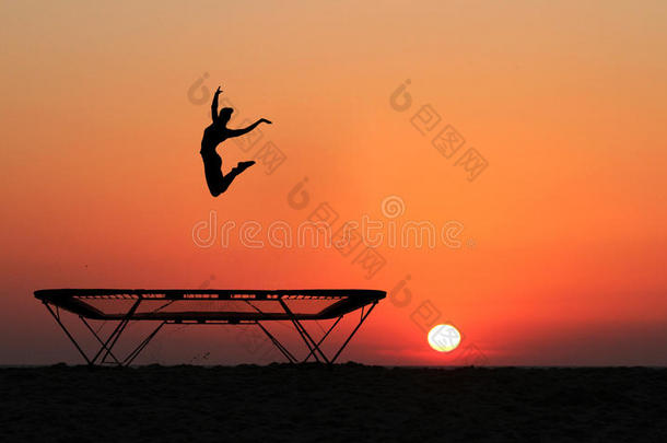 女子体操运动员蹦床跳跃的侧影