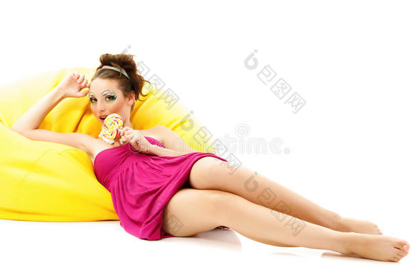 女人美妆年轻舔黄沙发上的糖果隔离