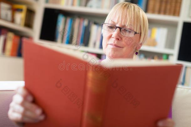 戴眼镜的老太太在家看书
