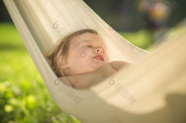 可爱的宝宝在阳光下的吊床上安静地睡觉