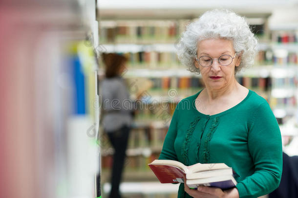老年妇女在图书馆读书选书