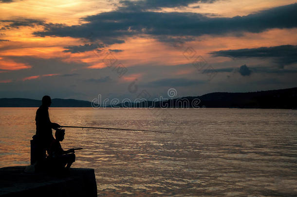 日落时码头上渔民的剪影