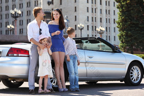 父亲、母亲和孩子站在汽车旁边